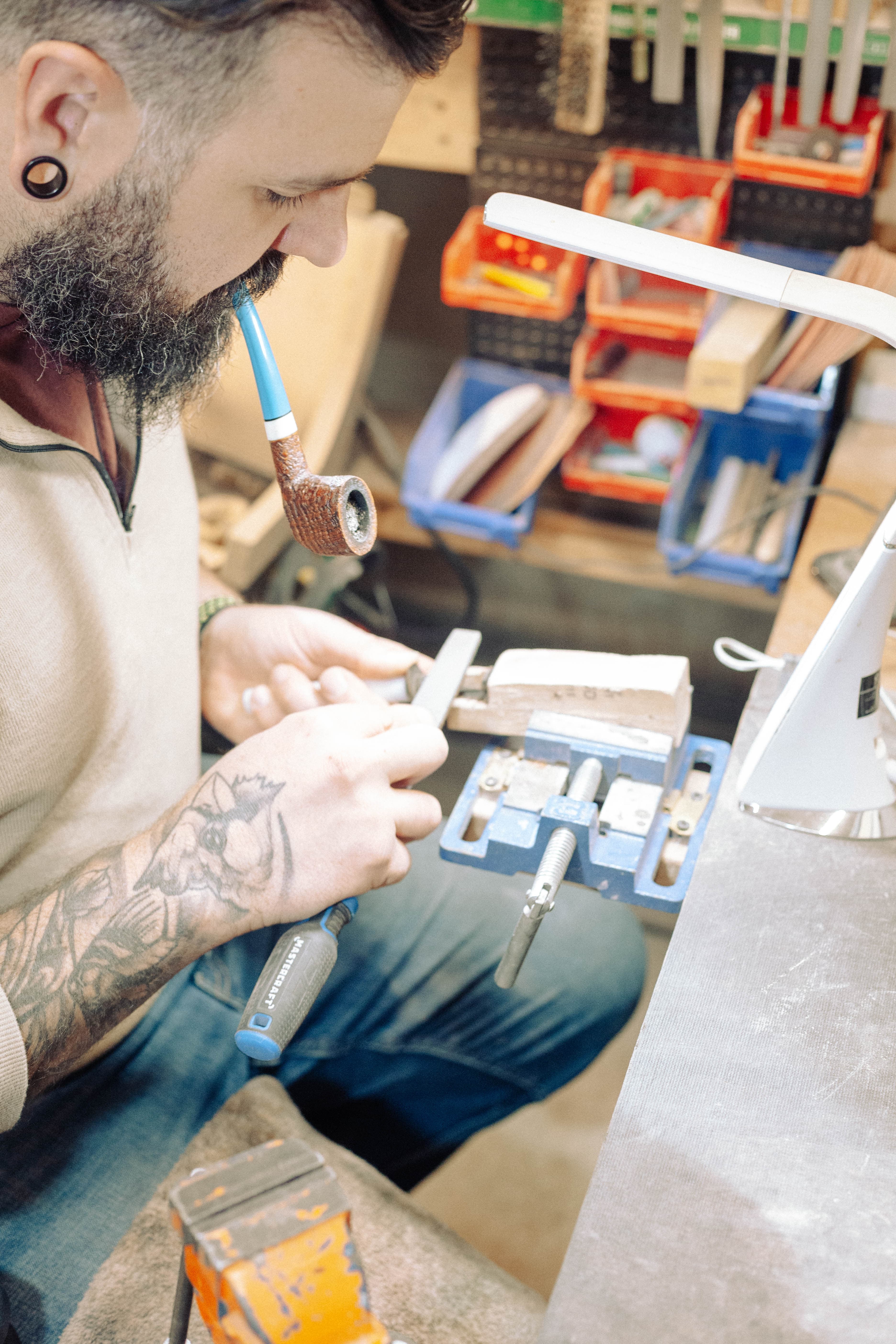 Nate Rose at his workbench crafting a pipe